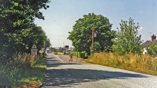 Approaching crossing at site of Hixon station, 1995 View westward, the station (unstaffed Halt since 20/7/31, closed 6/1/47 when local services ceased) had been on the left: ex-North Stafford Stone (to right) - Colwich (to left) loop used by London Euston - Manchester through trains running via Stoke-on-Trent and electrified in 1965-66. There was an RAF Airfield close by and the line was frequently blocked by crashing aircraft during World War Two, but the site is famous for the extraordinary accident of 6/1/68 when an express crashed into a low-loader creeping across the level-crossing carrying a 120-ton electrical transformer.
