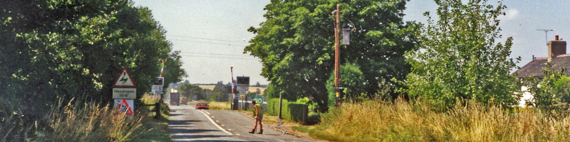 Approaching crossing at site of Hixon station, 1995 View westward, the station (unstaffed Halt since 20/7/31, closed 6/1/47 when local services ceased) had been on the left: ex-North Stafford Stone (to right) - Colwich (to left) loop used by London Euston - Manchester through trains running via Stoke-on-Trent and electrified in 1965-66. There was an RAF Airfield close by and the line was frequently blocked by crashing aircraft during World War Two, but the site is famous for the extraordinary accident of 6/1/68 when an express crashed into a low-loader creeping across the level-crossing carrying a 120-ton electrical transformer.