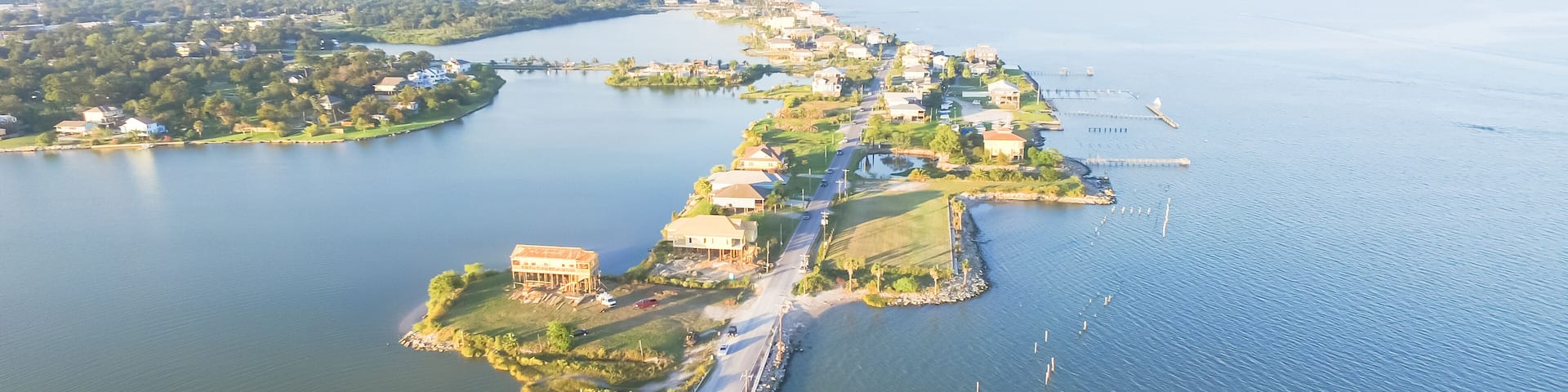 Panorama aerial view of Seabrook city near Texas Gulf Coast and Clear Lake. Waterfront harbor town with pier. Wooden vacation house under construction. Real estate and beach travel background