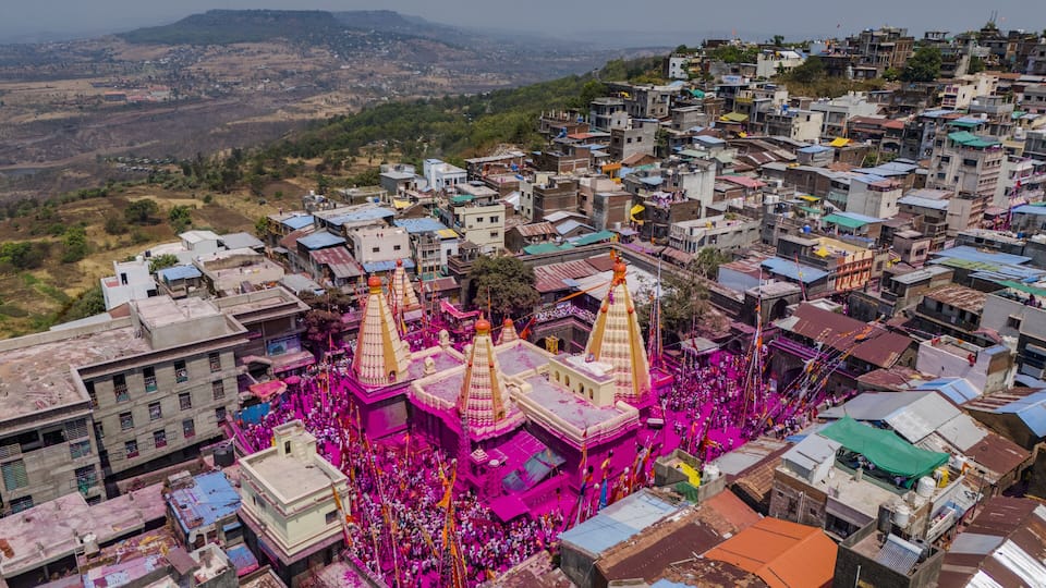 A densely packed urban area with colorful buildings and a prominent temple with golden spires.