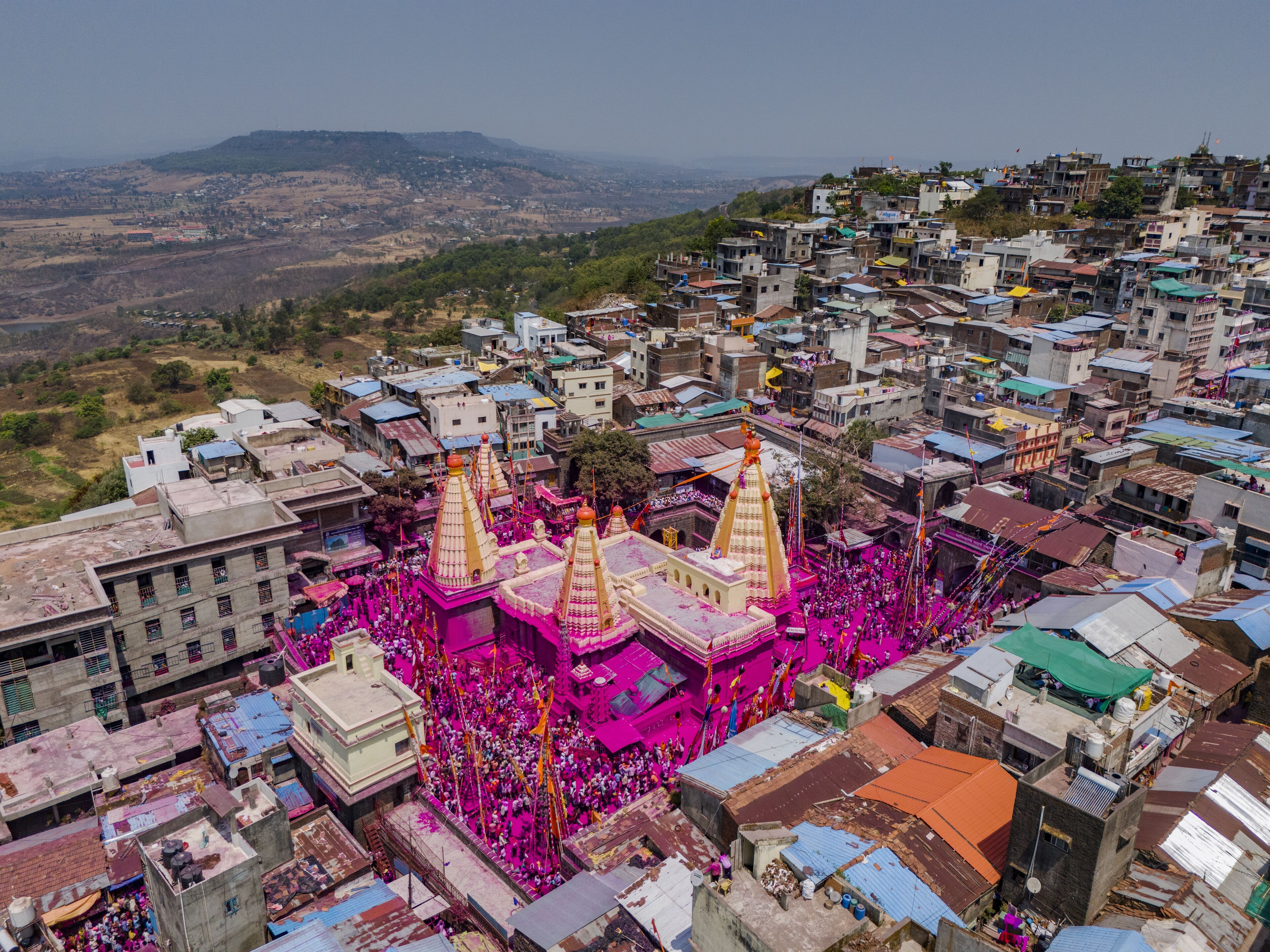 A densely packed urban area with colorful buildings and a prominent temple with golden spires.