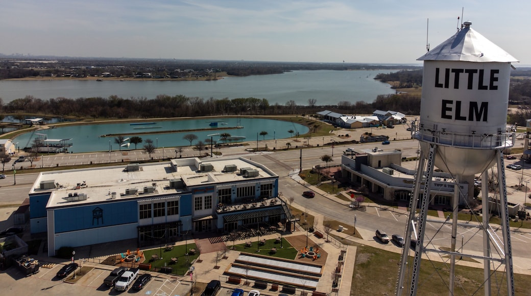 Aerial view of a water tower standing tall against the backdrop of a serene lake, with buildings nestled along the shore, Little Elm, Texas, United States.
