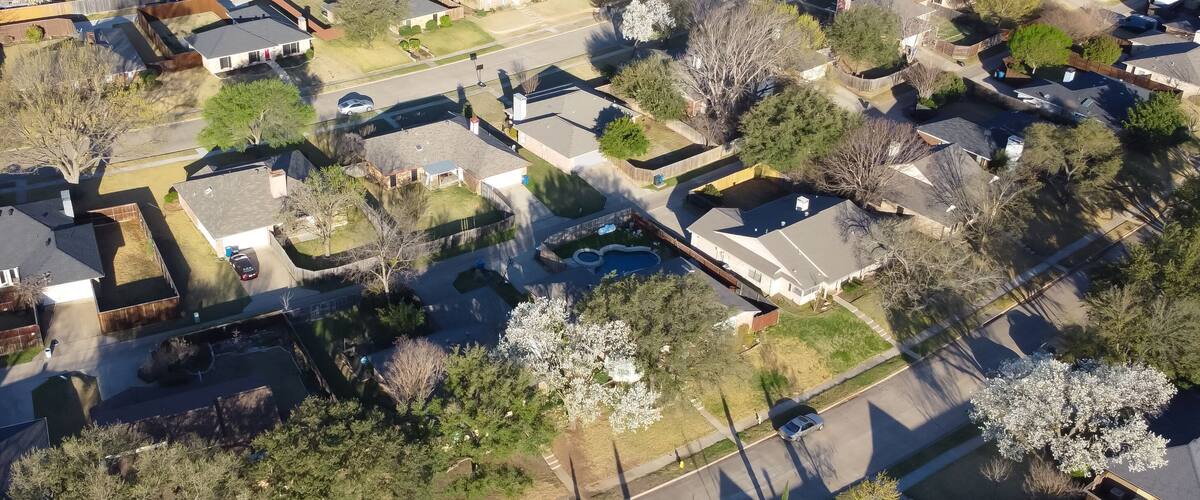 An aerial view of a residential neighborhood with houses, streets, and trees.
