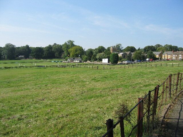 Rushton, Northamptonshire. Looking across from the High Street to the cricket pitch and Church