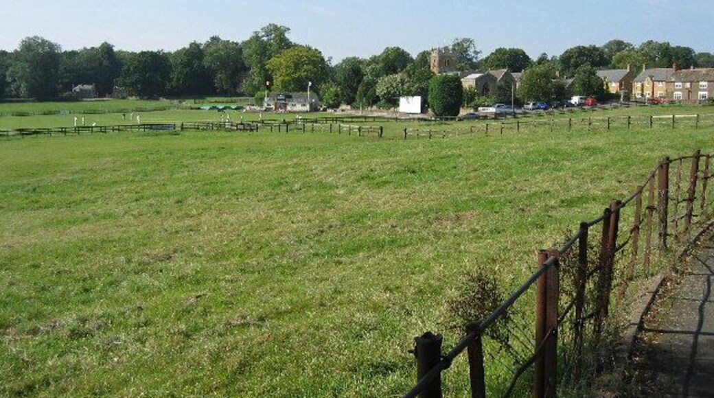 Rushton, Northamptonshire. Looking across from the High Street to the cricket pitch and Church