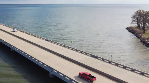Panoramic Aerial view rock wall shoreline lakefront and Two Mile Bridge over Lake Tawakoni to horizontal line in Quinlan, Texas