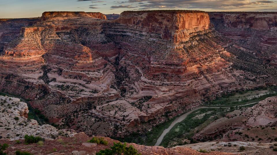 A canyon with layered rock formations and a winding river.