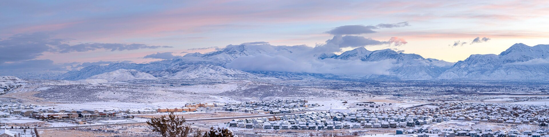 Un pueblo nevado con montañas al fondo.