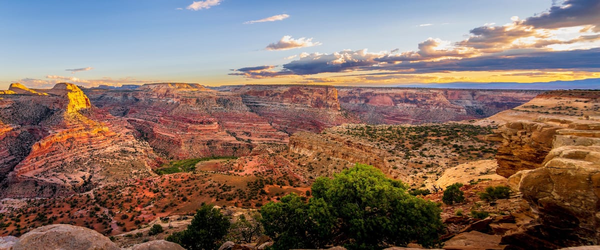 A canyon with layered rock formations and a prominent rock spire.