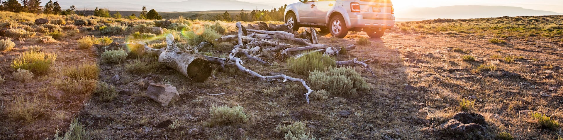 SUV car at sunrise in natural setting, Koosharem, Utah, USA