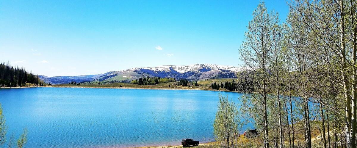 A clear blue lake surrounded by trees and mountains.