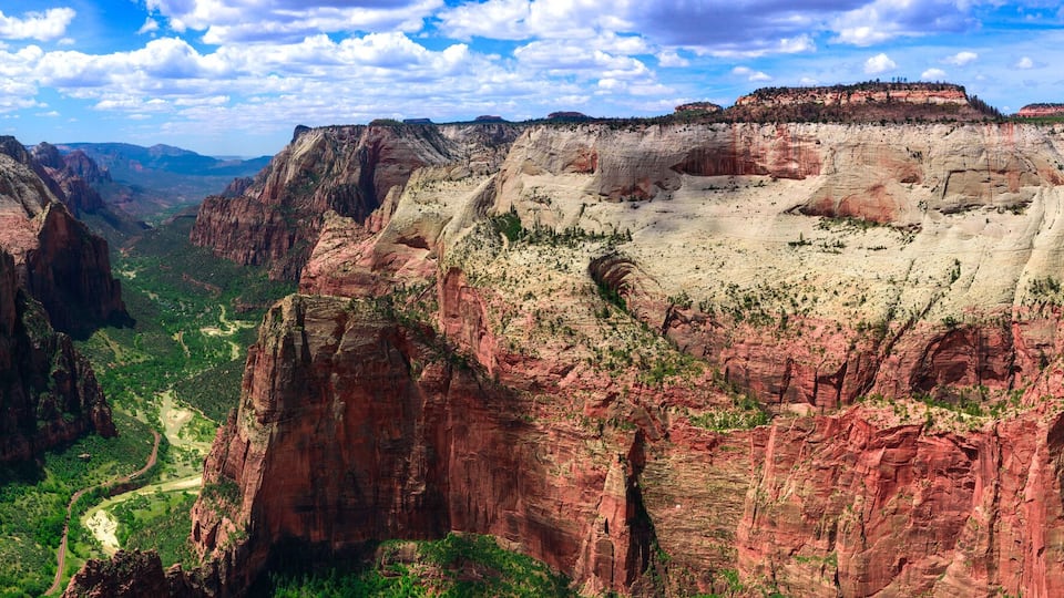 A canyon with steep cliffs and a winding road.