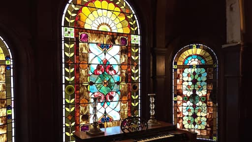 The organ and stained glass windows on the landing between the first and second floors.