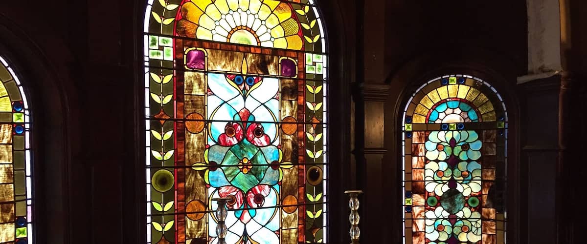 A church interior with stained glass windows and a piano.