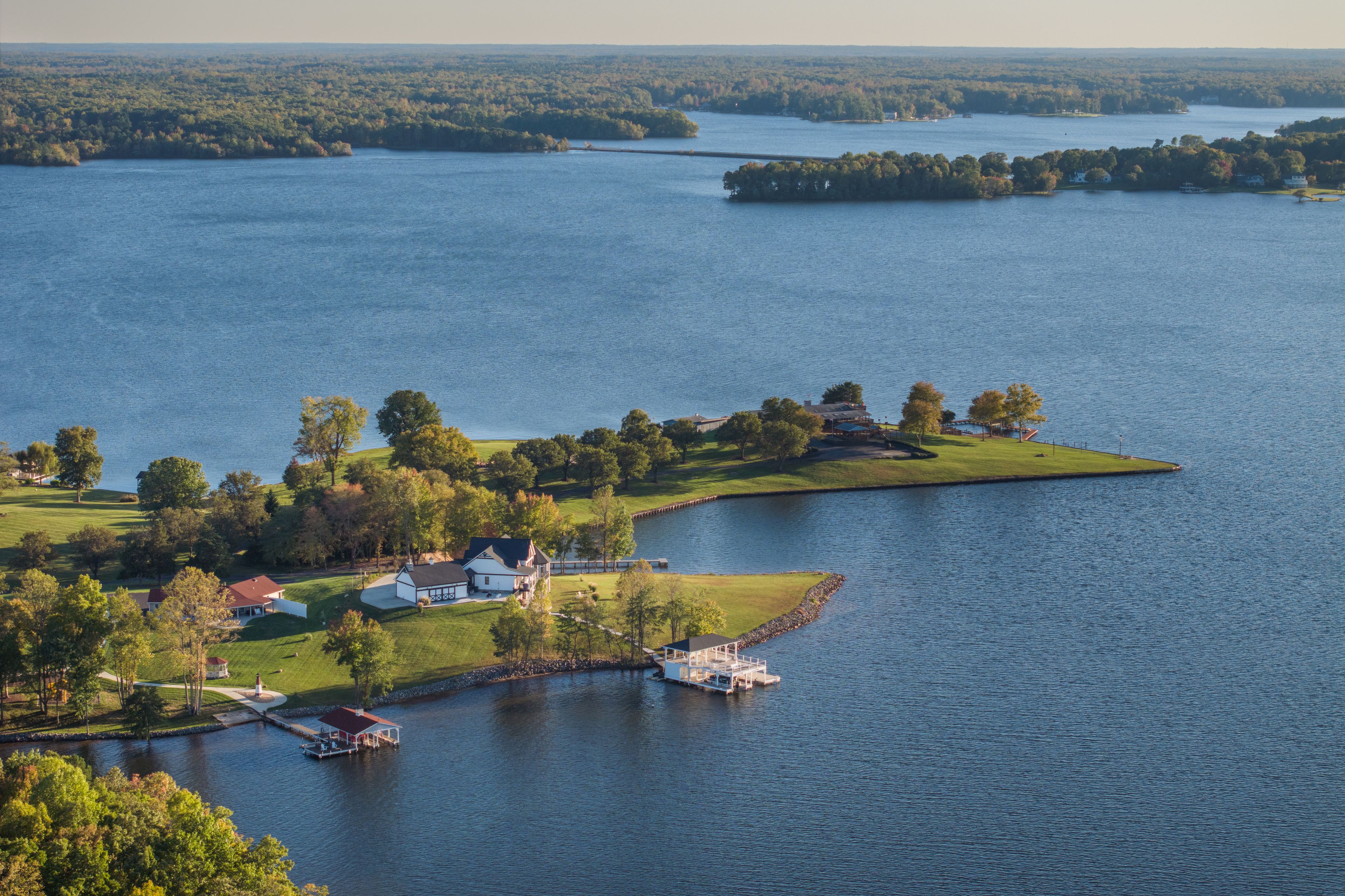 A lakeside community with houses, docks, and a lighthouse.