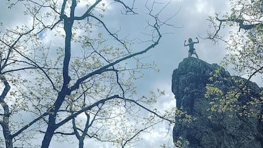A rocky landscape with a person standing on a large rock formation.