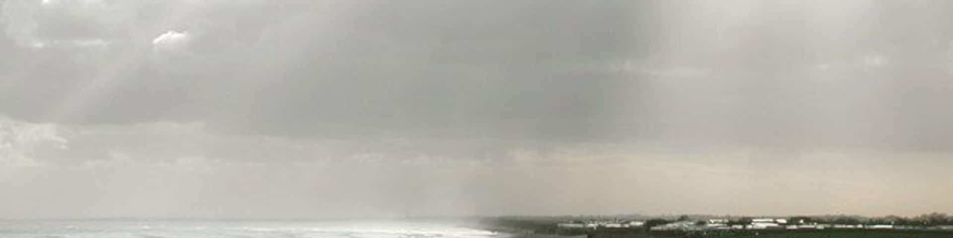 South Field, Barmston, East Riding of Yorkshire, England. Looking south across Barmston Drain towards Ullrome caravan park. There's an odd little bit of Barmston parish just south of here, where the parish boundary wanders out across the beach and back inland at 'Highlands' just north of the caravan park in the picture. Whatever feature caused the boundary to take this course has long ago been lost to coastal erosion.