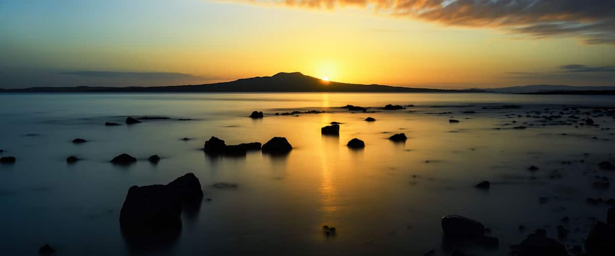 Long exposure image of sunrise over Rangitoto Island. Takapuna Beach. Auckland.