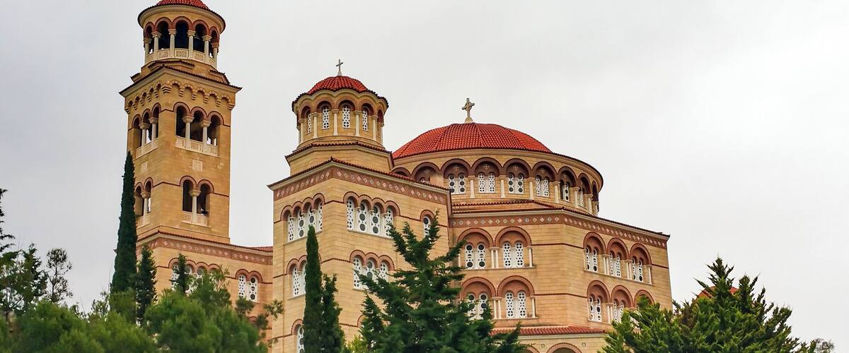 A large, ornate building with multiple towers and a red-tiled dome.