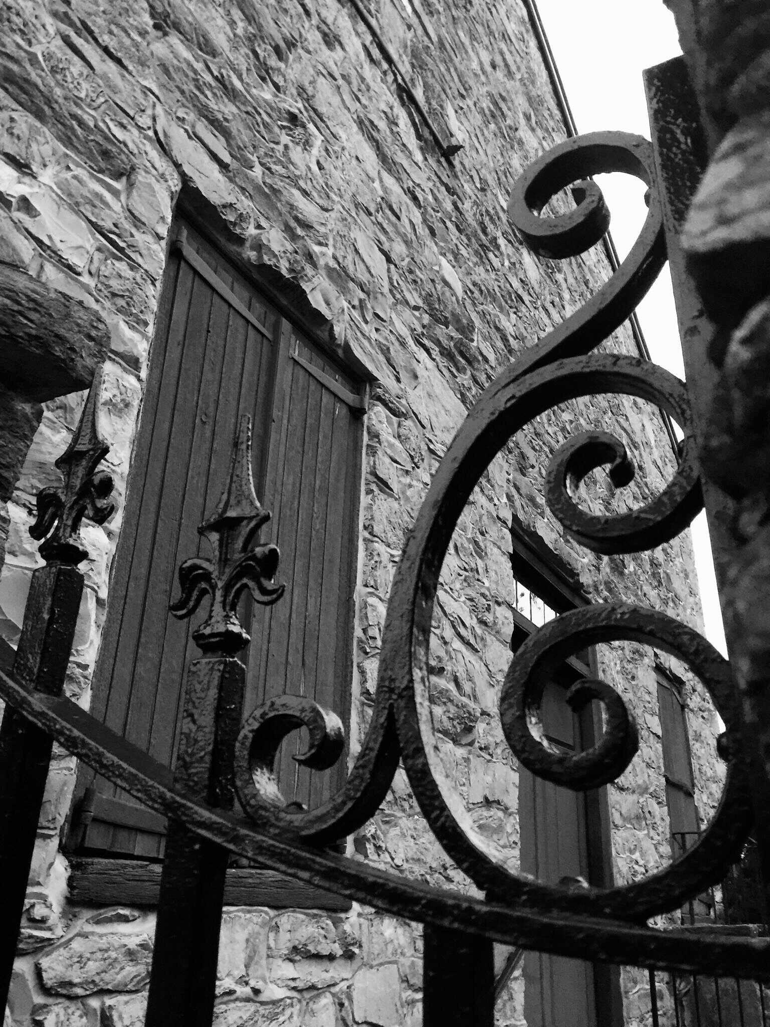A stone building with a wooden door and decorative ironwork.