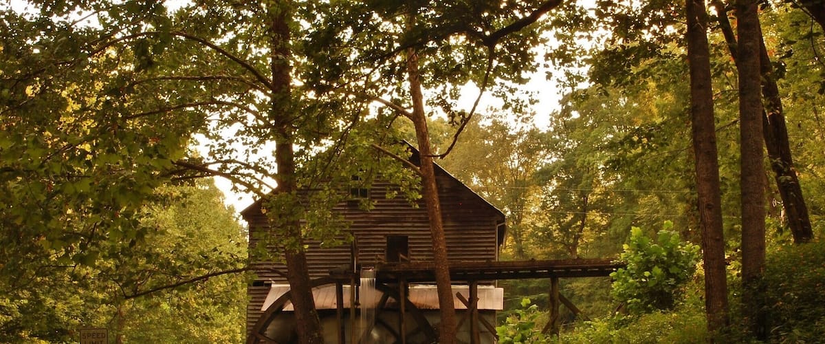 A watermill in a forested area with a speed limit sign of 40.