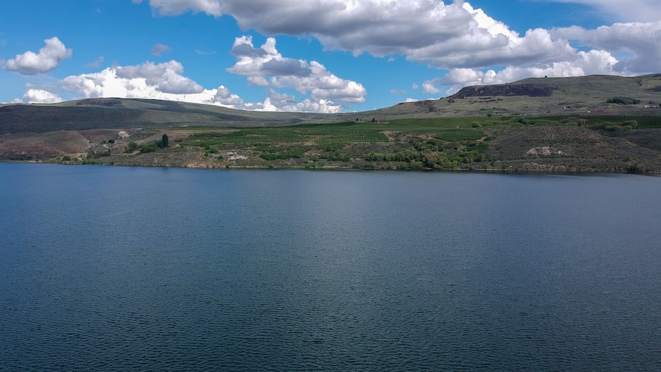 A lake with a clear sky and scattered clouds.