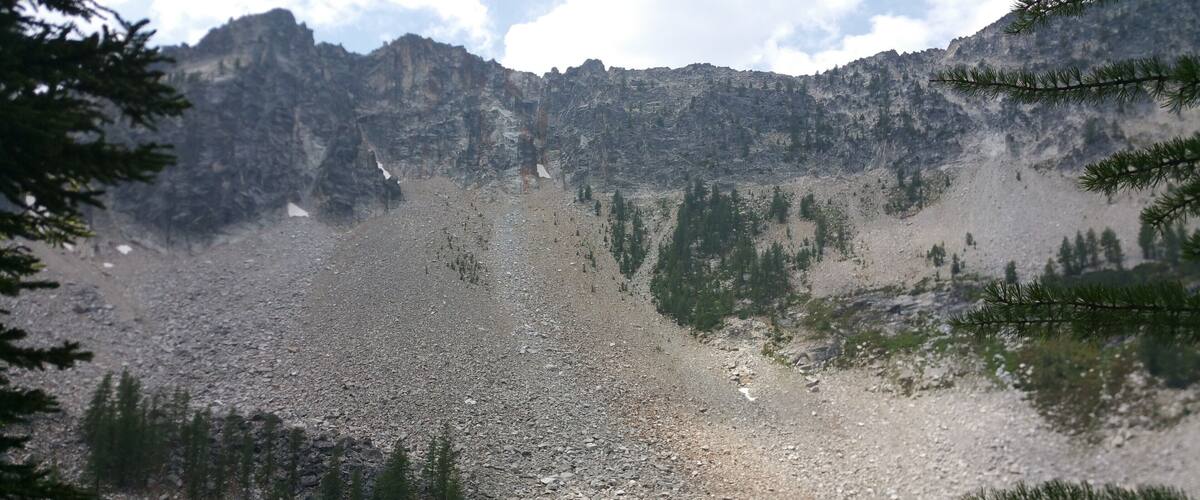A mountain lake surrounded by rocky terrain and sparse trees.