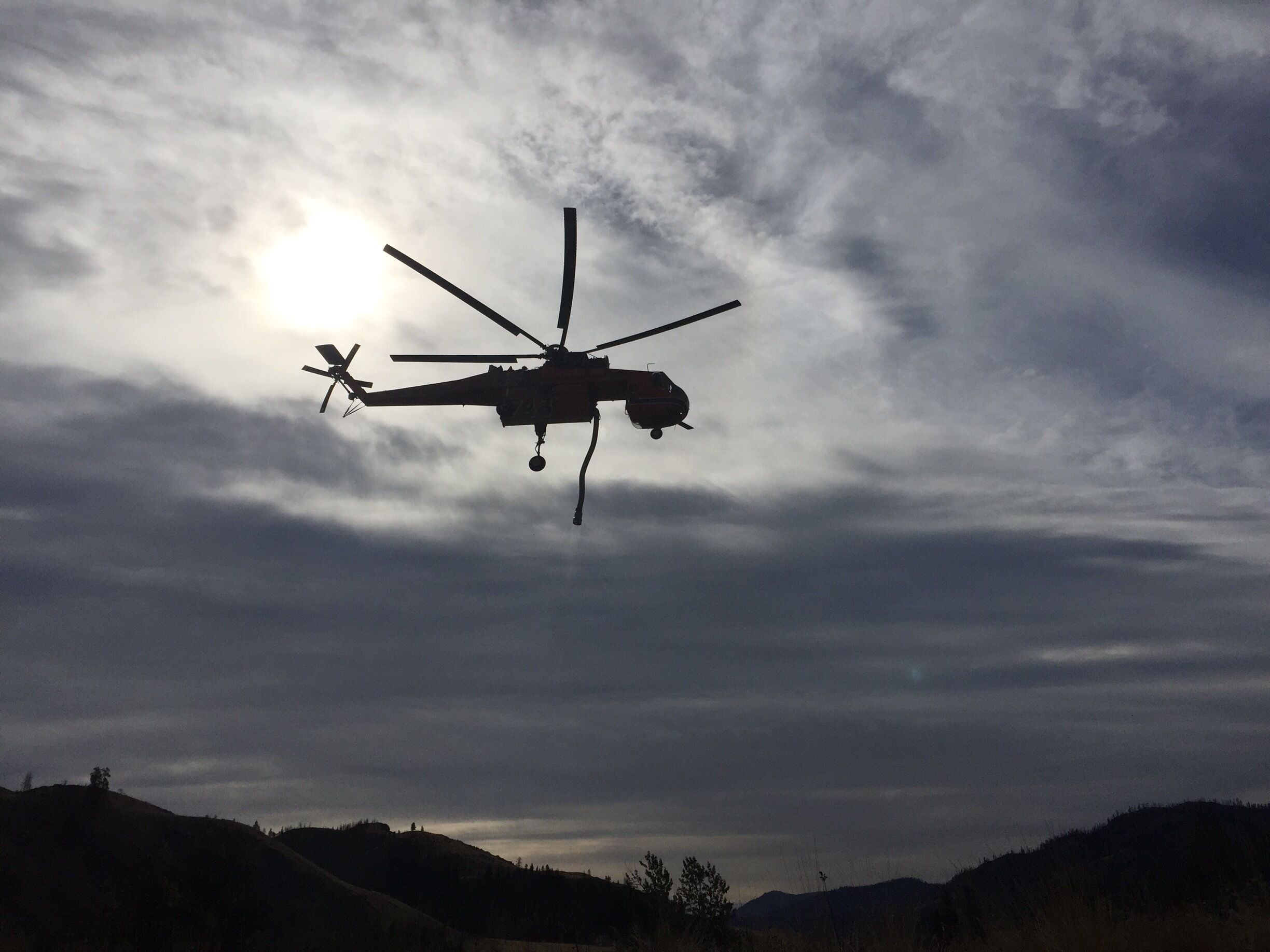 Still a few hot spots to work on in Washington   We watched the helicopter dip below a hill and as we rounded the corner, the helicopter was ascending back into the sky with its tanks full. Thanks to all the firefighters that helped in this area. 