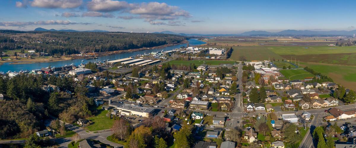 A town with a river, industrial buildings, and agricultural fields.