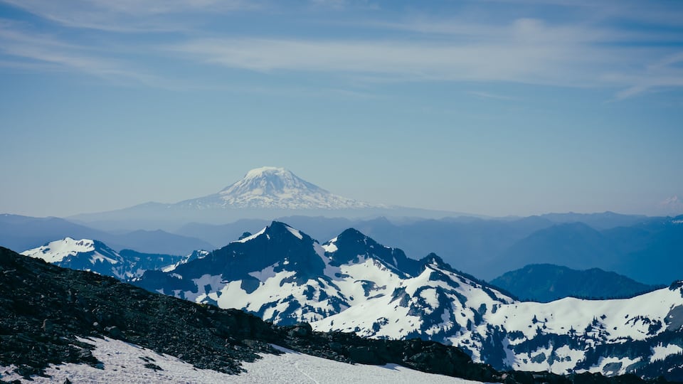 A snow-covered mountain range with a prominent peak in the background.