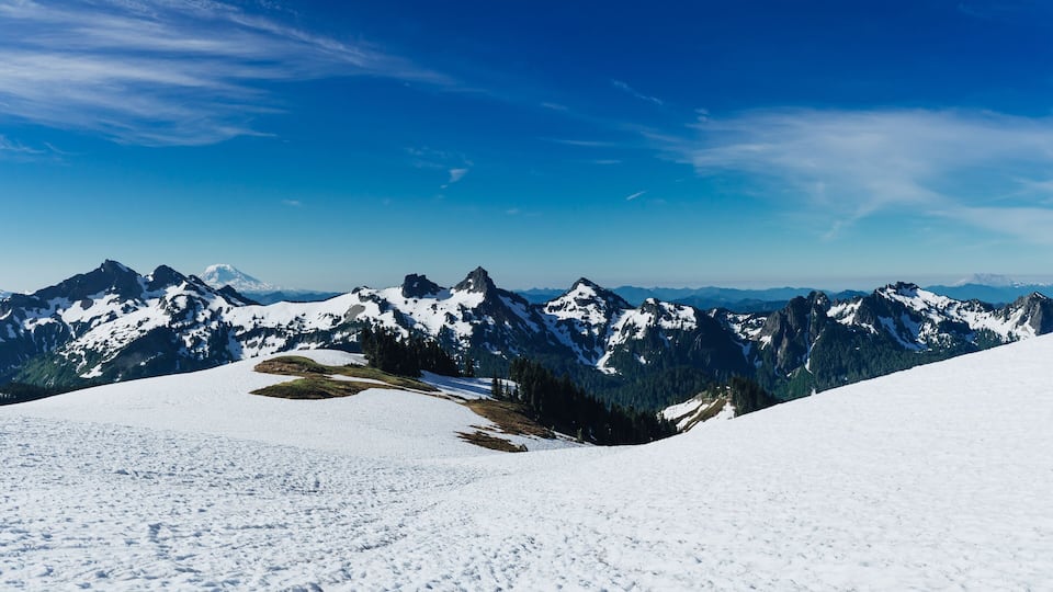 A snow-covered mountain range with clear blue skies.