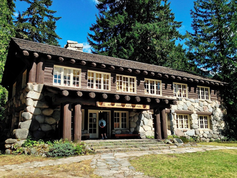 When Mount Rainier National Park was established in 1899 the park headquarters were located at the site of James Longmire's homestead and mineral springs resort. Over the subsequent decades a number of architecturally significant buildings were constructed, including the Administration Building pictured here.
What sets this building apart is the use of glacial boulders to form much of the first story walls. Massive log beams and log-siding complete the structure, while a large fireplace dominates the lobby. Overall, the building appears largely the same as it did when built in the late 1920s.
Today the building serves as a visitor information center.
#Architecture