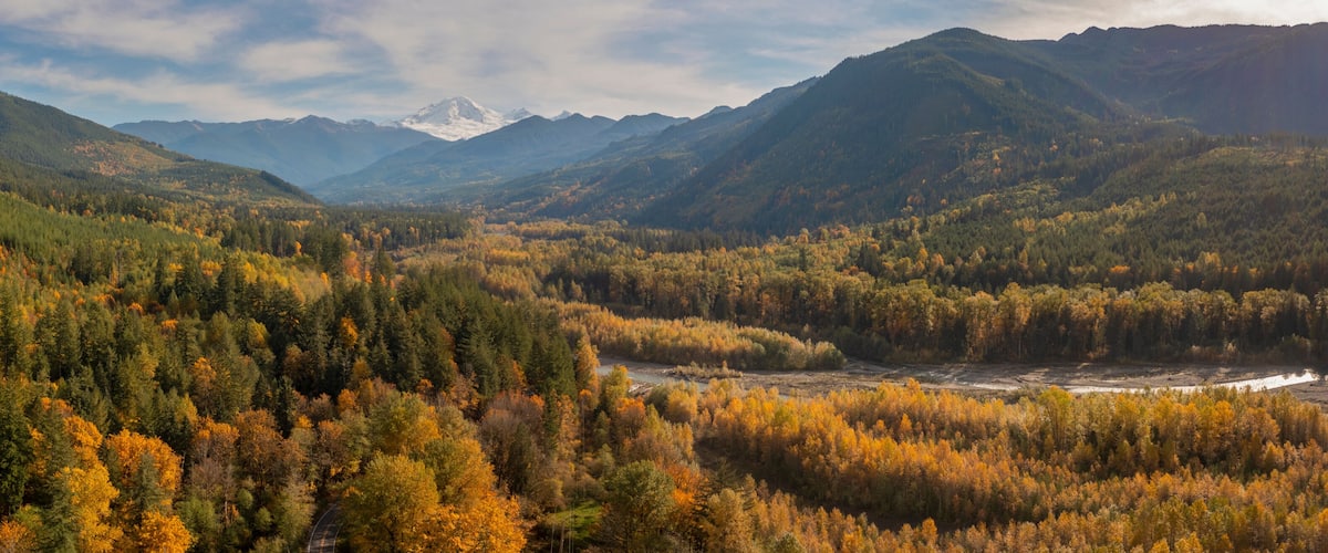 A mountainous landscape with dense forests and a river.