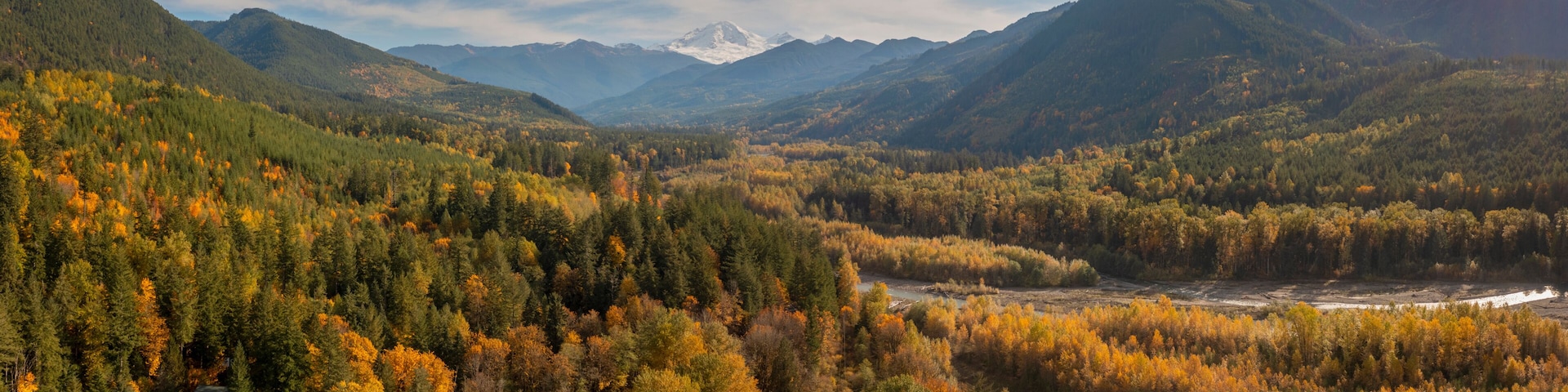 A mountainous landscape with dense forests and a river.