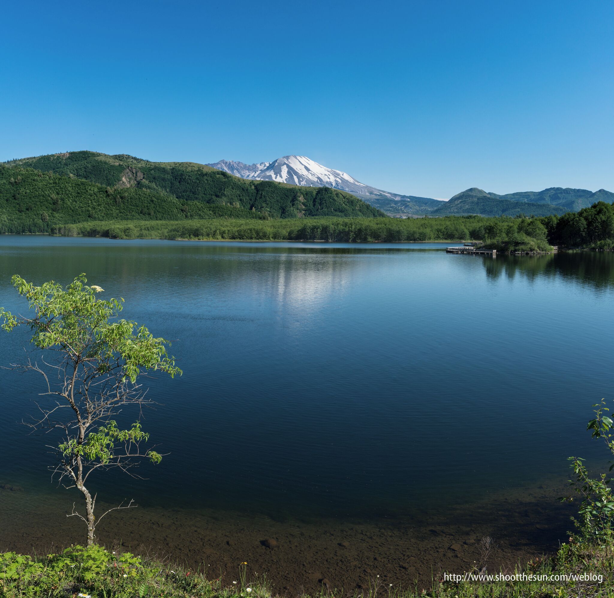 A calm lake with a mountain in the background.