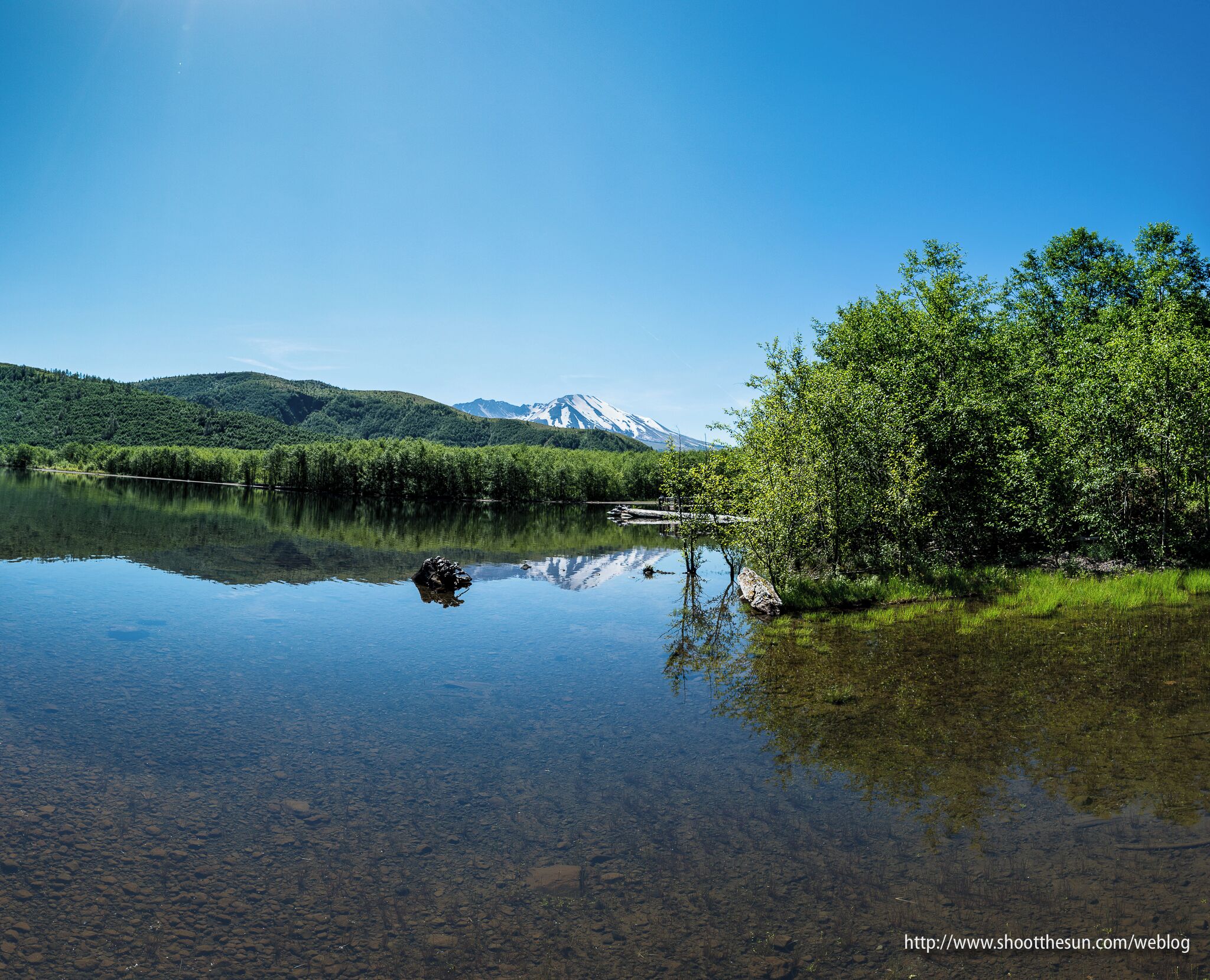 A clear lake with a mountain in the background.