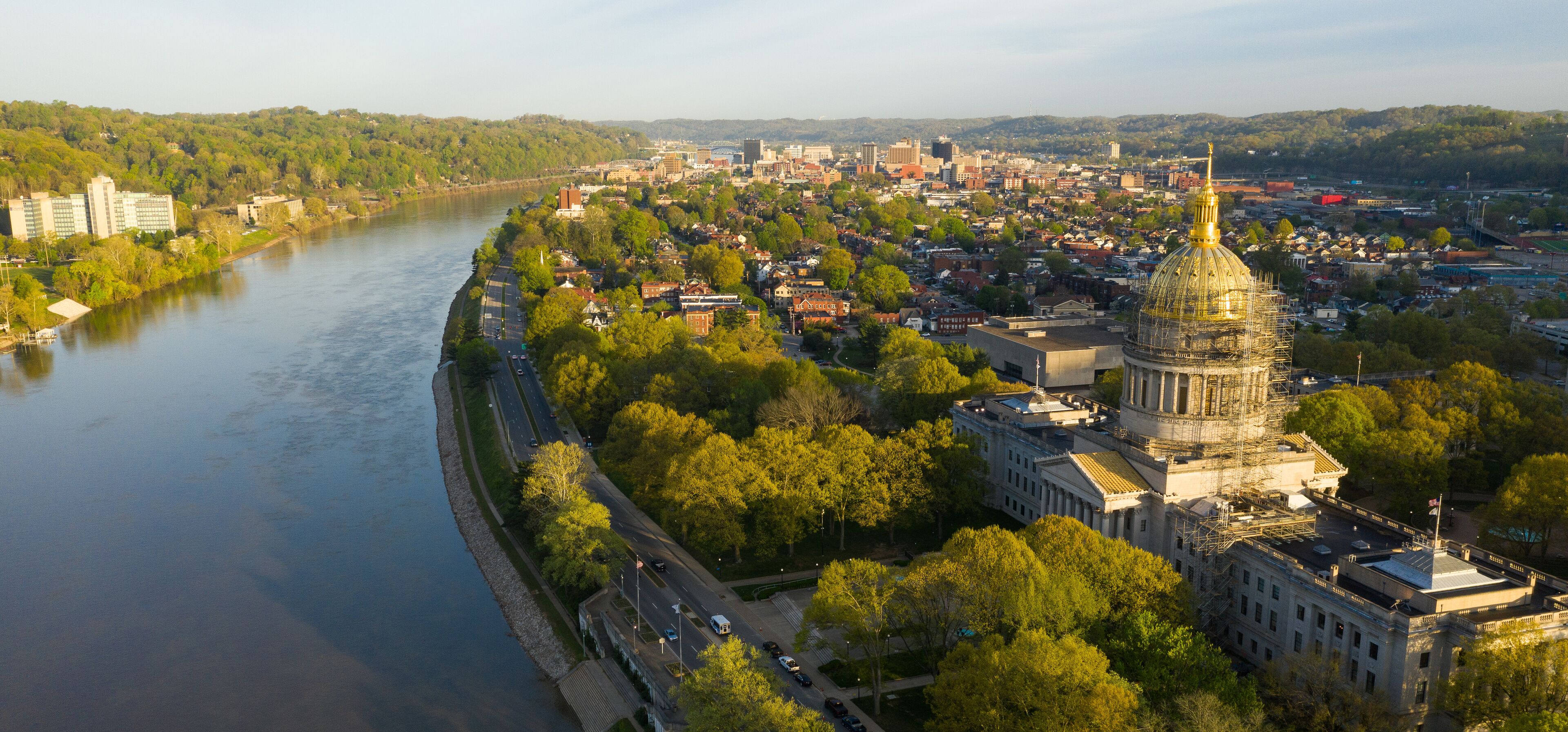 A river, a cityscape with a prominent dome-shaped building, and surrounding greenery.