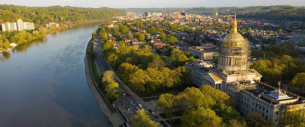 A river, a cityscape with a prominent dome-shaped building, and surrounding greenery.