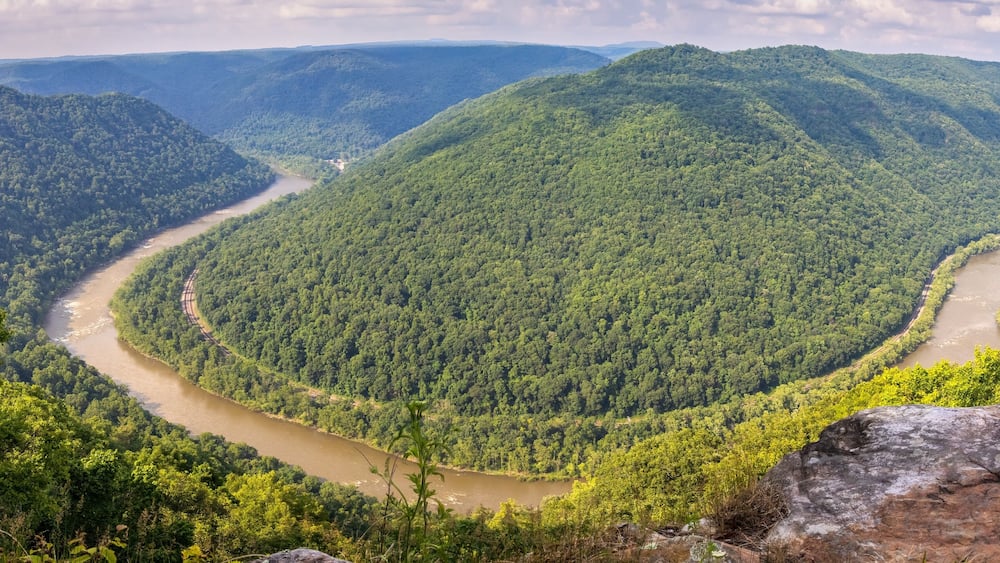 New River flowing through the New River Gorge National Park with With White Water Rafts on Rapids Around Central Island