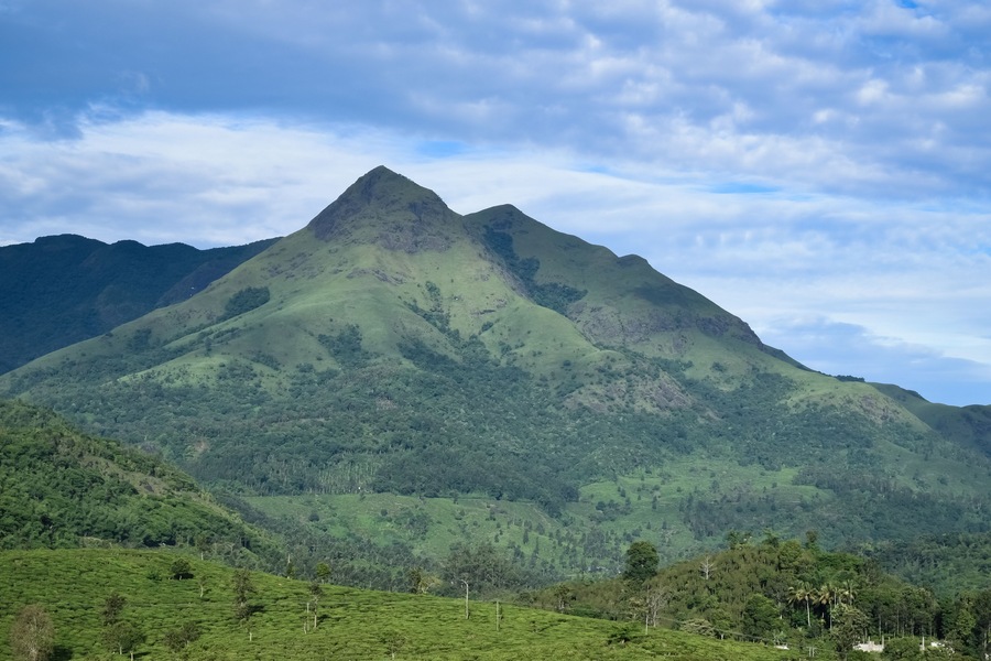 Landscape oriented wallpaper poster background of highest mountain in wayanad Chembra peak hills on a hazy day in Meppadi.