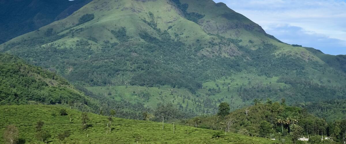 A mountain range with lush green hills and a clear sky.