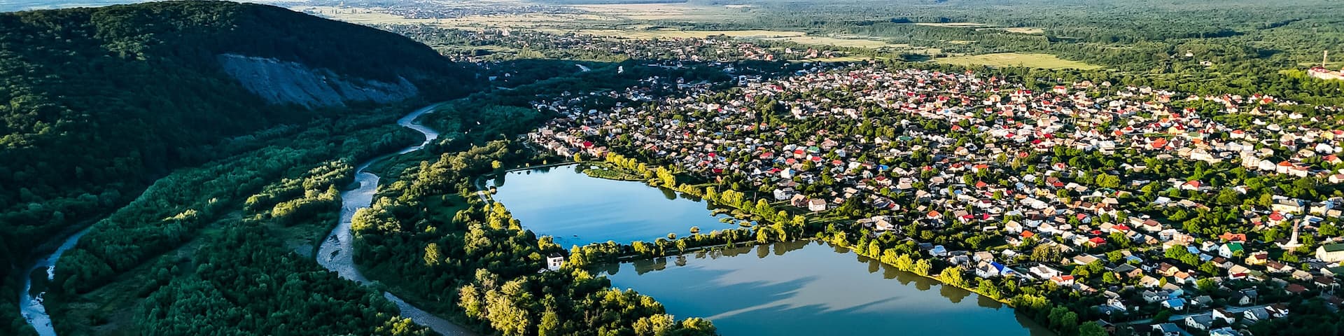 Twin lakes mirror the sky next to a compact town bordered by sweeping woodland