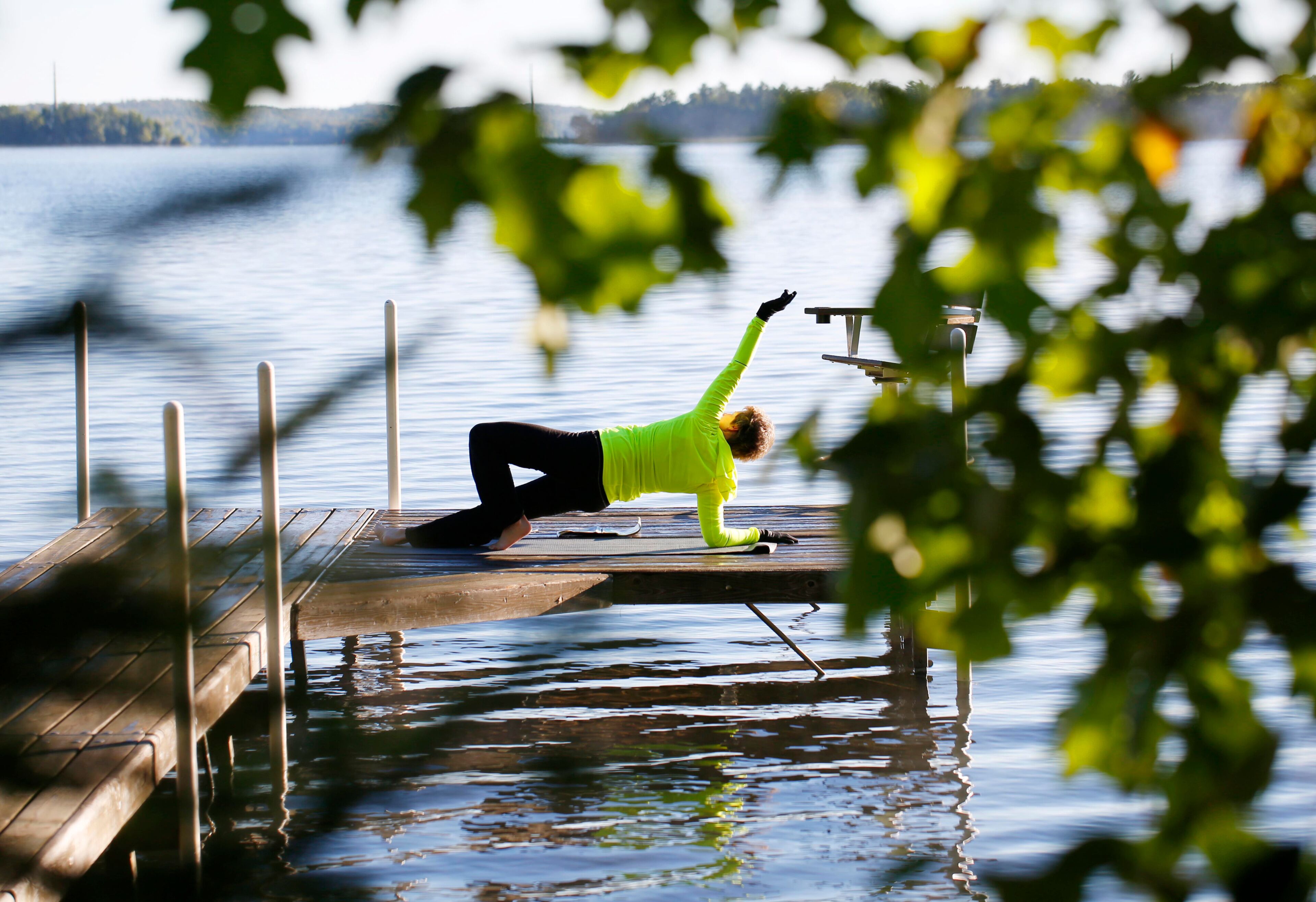 A woman does stretches on a pier on South Twin Lake in Conover, Wisconsin