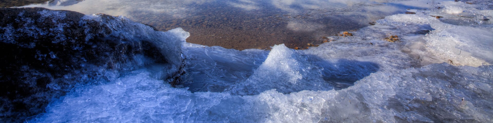 A frozen lake with mountains in the background.