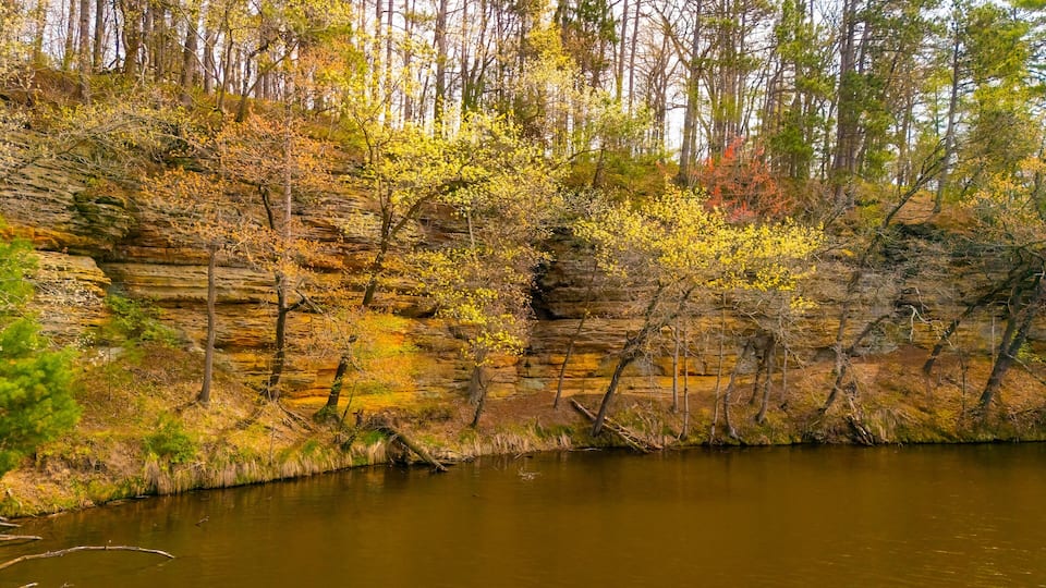 A river with rocky cliffs and autumn foliage.