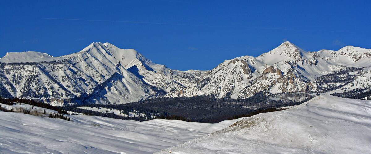 A snow-covered mountain range with clear blue skies.