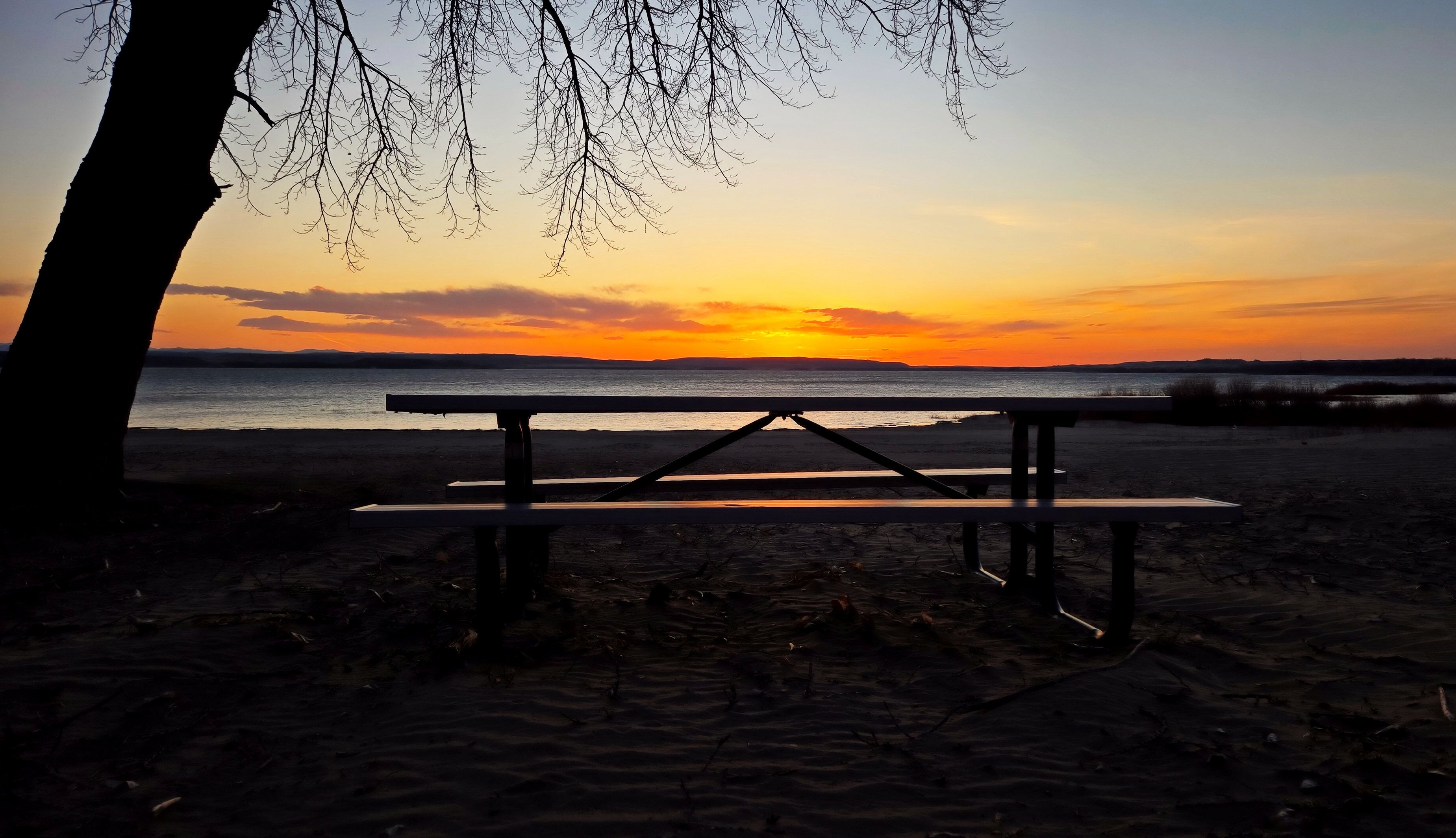 Reflection of sunset on picnic table 