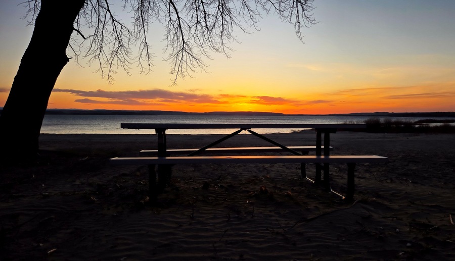 Reflection of sunset on picnic table