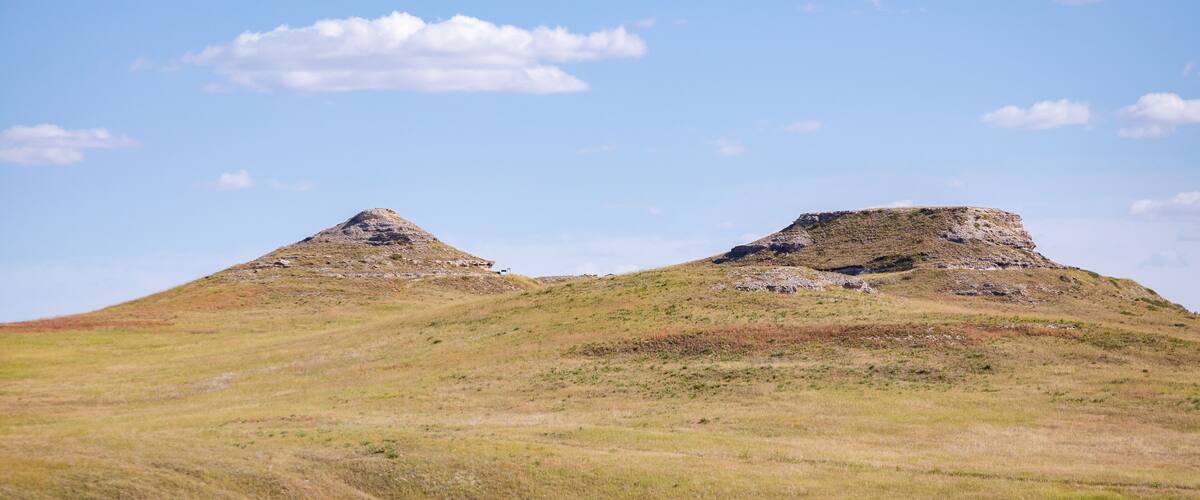 A grassy hill with two prominent mounds.