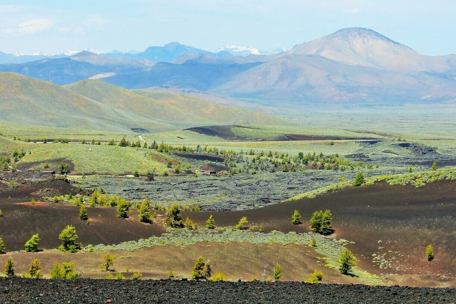 This is Craters of the Moon from the view atop Inferno Cone. A lot of contrast going on here with life springing from the ashes of lava tubes and spatter cones all atop a series of caves and tunnels to explore.
I'd say go before July or the heat reflecting off the Obsidian may be too much to handle. If you come after that... run to the caves where it will be 15 - 20 degrees cooler.
Ooh, one last tip if you're camping in the campground try to get site #13. It's super private and makes you feel like you're in a crater. Otherwise try to book the group site as it's the only one that will allow a proper fire. :)
